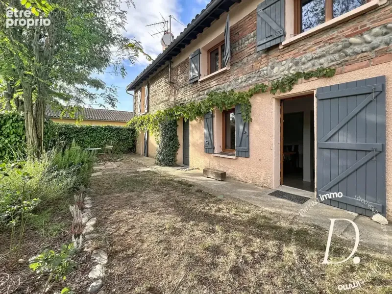 Façade en brique et galets avec ses volets bois
