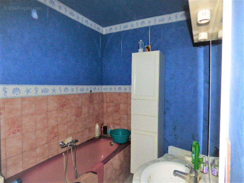 Une salle de bains avec baignoire et un meuble vasque - Maison à LES HAUTS-DE-CHEE
