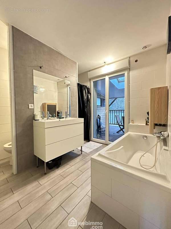 La salle de bains avec double vasque sur meuble, une baignoire, une douche à l&#039;italienne et un wc - Maison à LAON