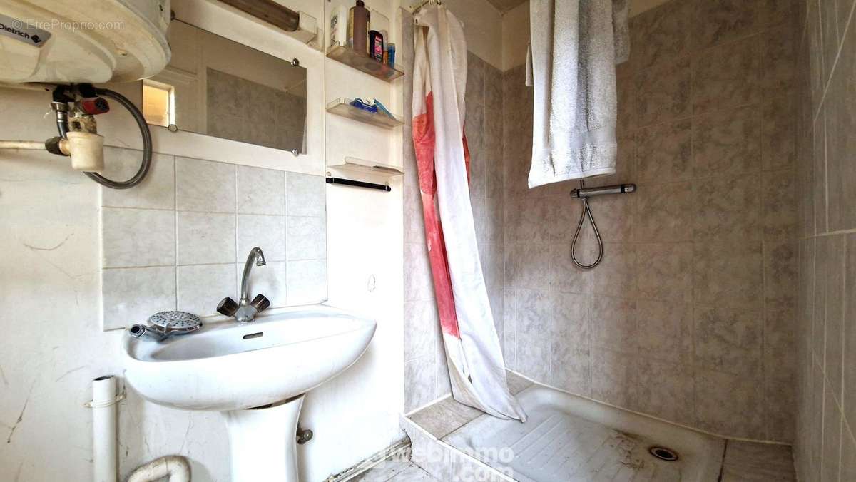 Une salle de douche avec lavabo - Appartement à LAON
