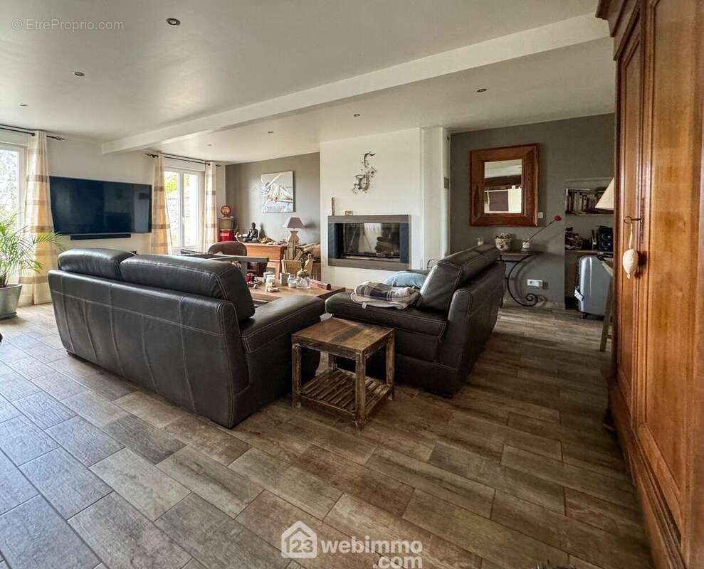 Le salon est chaleureux avec sa cheminée à foyer fermé - Maison à MENOMBLET