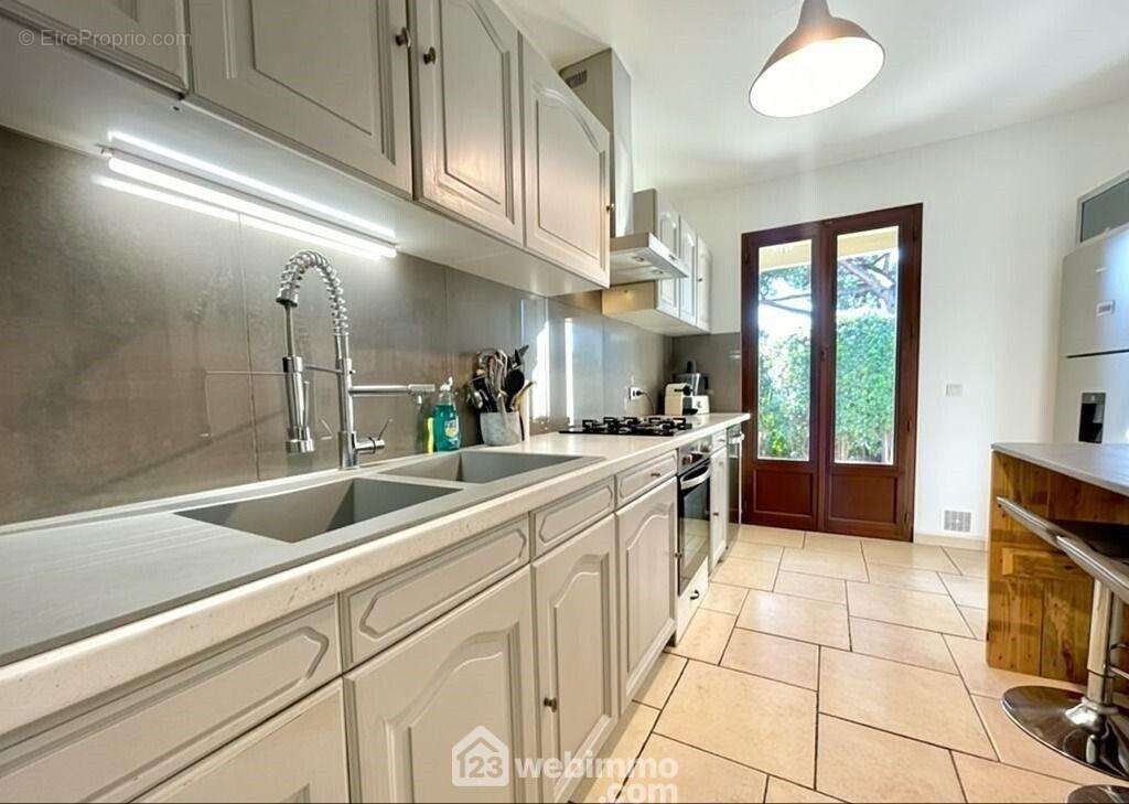 Cuisine aménagée avec accès direct à l?extérieur, idéale pour vos repas en terrasse. - Maison à SAINTE-MAXIME