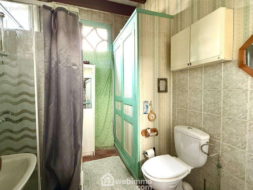 Une salle de douche avec toilettes. - Maison à LONGUE-JUMELLES