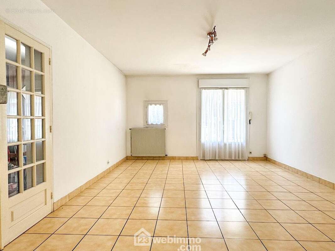 Le séjour de 23.30m² accède à la cuisine partiellement ouverte. - Maison à CHOLET