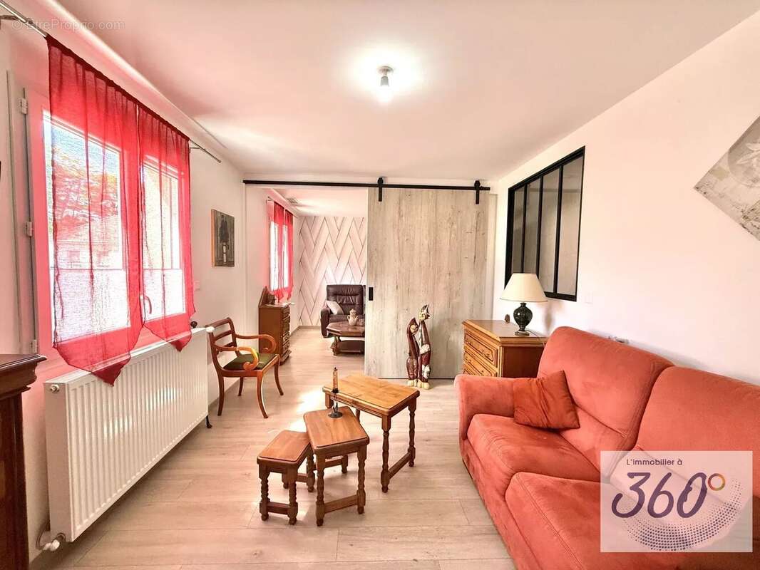 Un salon lumineux donnant sur une autre pièce. - Maison à BRANGES