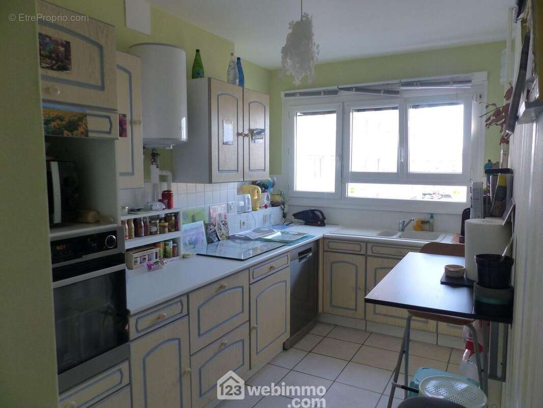 La cuisine aménagée et équipée de 10 m2 et son coin repas. - Appartement à BIHOREL