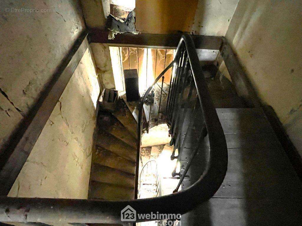 L&#039;escalier central permet l&#039;accès aux étages. - Maison à MIREBEAU